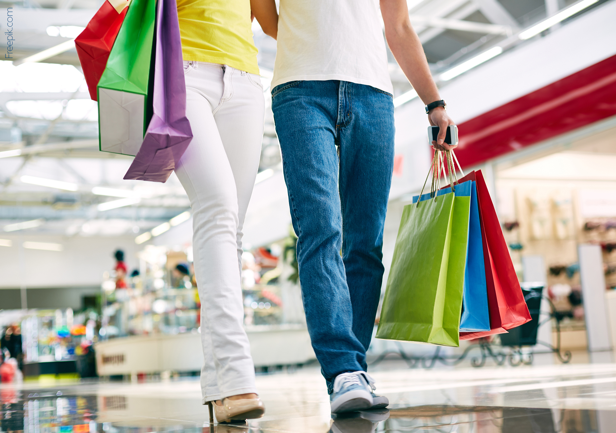 Legs of young couple going in the mall