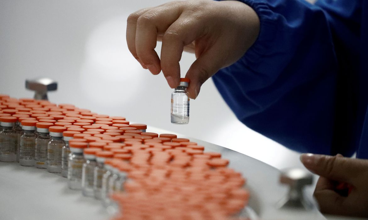 FILE PHOTO: A worker performs a quality check in the packaging facility of Chinese vaccine maker Sinovac Biotech, developing an experimental coronavirus disease (COVID-19) vaccine, during a government-organized media tour in Beijing, China, September 24, 2020. REUTERS/Thomas Peter/File Photo