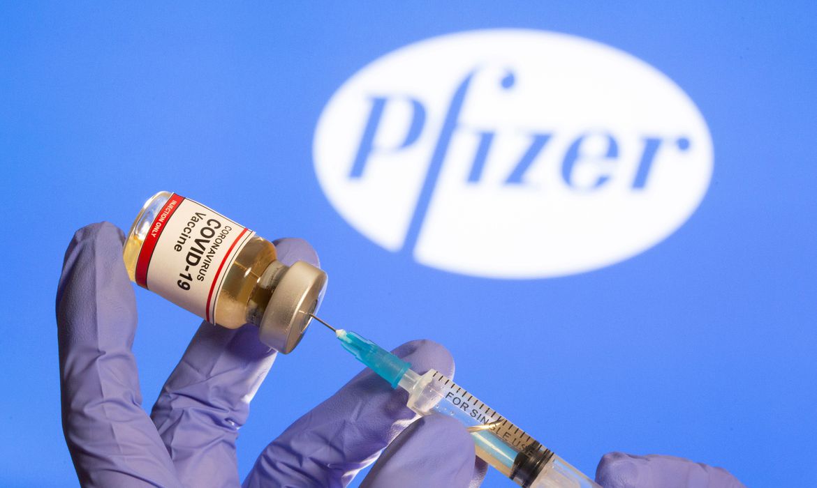 Mulher segura frasco rotulado como de vacina contra Covid-19 em frente a logo da Pfizer em foto de ilustração
30/10/2020 REUTERS/Dado Ruvic