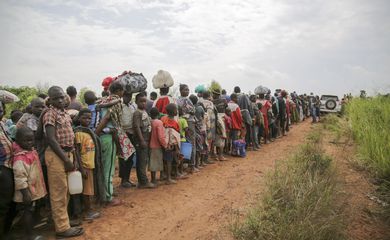 Congolese asylum-seekers line up to undergo security and health screening in Zombo, near the border between Uganda and the Democratic Republic of Congo. ; In July 2020, UNHCR, the Government of Uganda and partners mounted an emergency operation in the Zombo district to receive thousands of asylum-seekers stranded in no-man's land between Uganda and the Democratic Republic of the Congo (DRC) since late-May. The Guladjo and Mount Zeu border points have been opened for three days to receive civilians who are among an estimated 45,000 people displaced by militia violence in eastern DRC. Like many countries, Uganda closed its borders in March to contain the spread of COVID-19. Upon arrival at the border, all asylum-seekers underwent security and health screening. Vulnerable individuals were identified and fast-tracked for assistance. Mandatory 14-day quarantine and COVID-19 testing is being carried out at Zewdu Farm Institute, where arrivals are being registered and given food and basic aid.