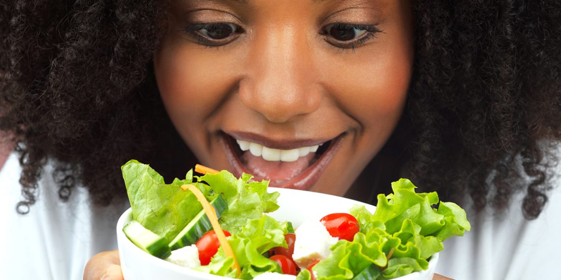 Studio shot of an attractive young woman eating salad