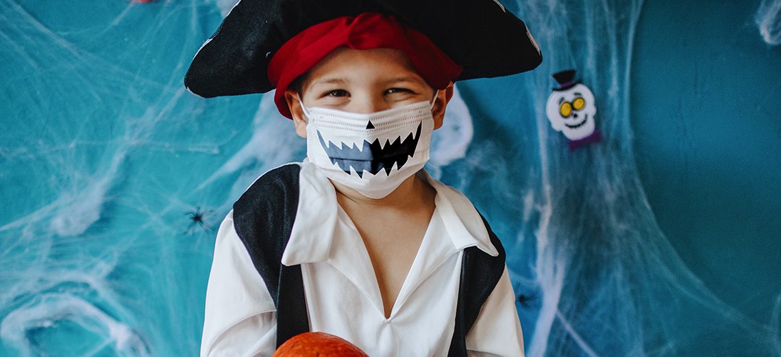 Little boy wearing Halloween costume and protective face mask during Covid-19 pandemic