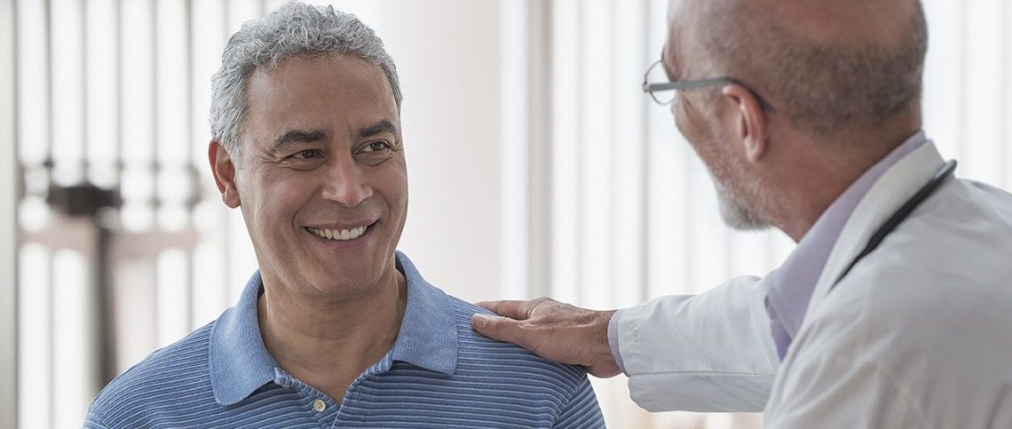 Doctor using digital tablet and talking to patient in office