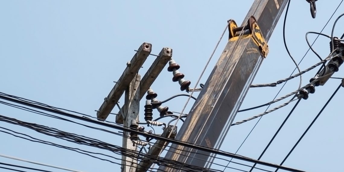 Selective focus of electricians are fixing power transmission line on a electricity pole