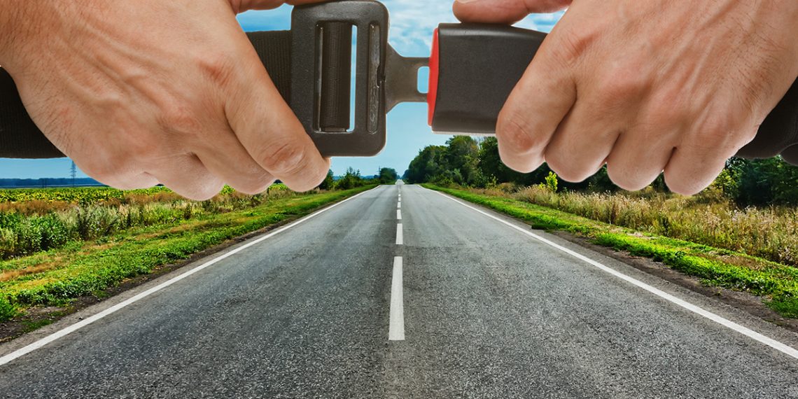 Hands,Button,Safety,Belt,On,The,Background,Of,The,Road
