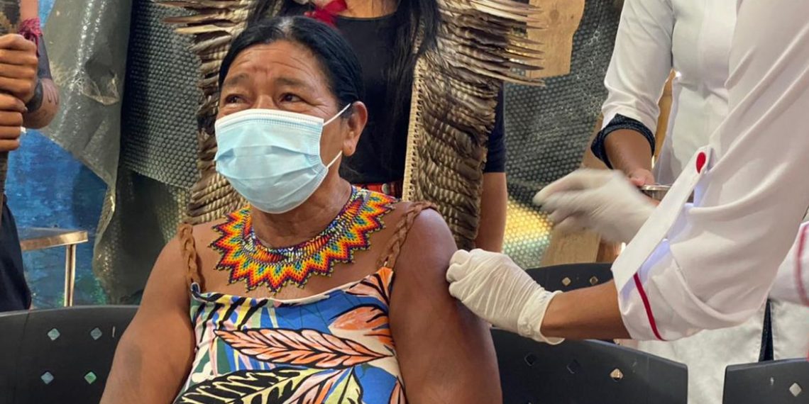 Senhora ndigéna recebendo a dose da vacina contra a covid-19