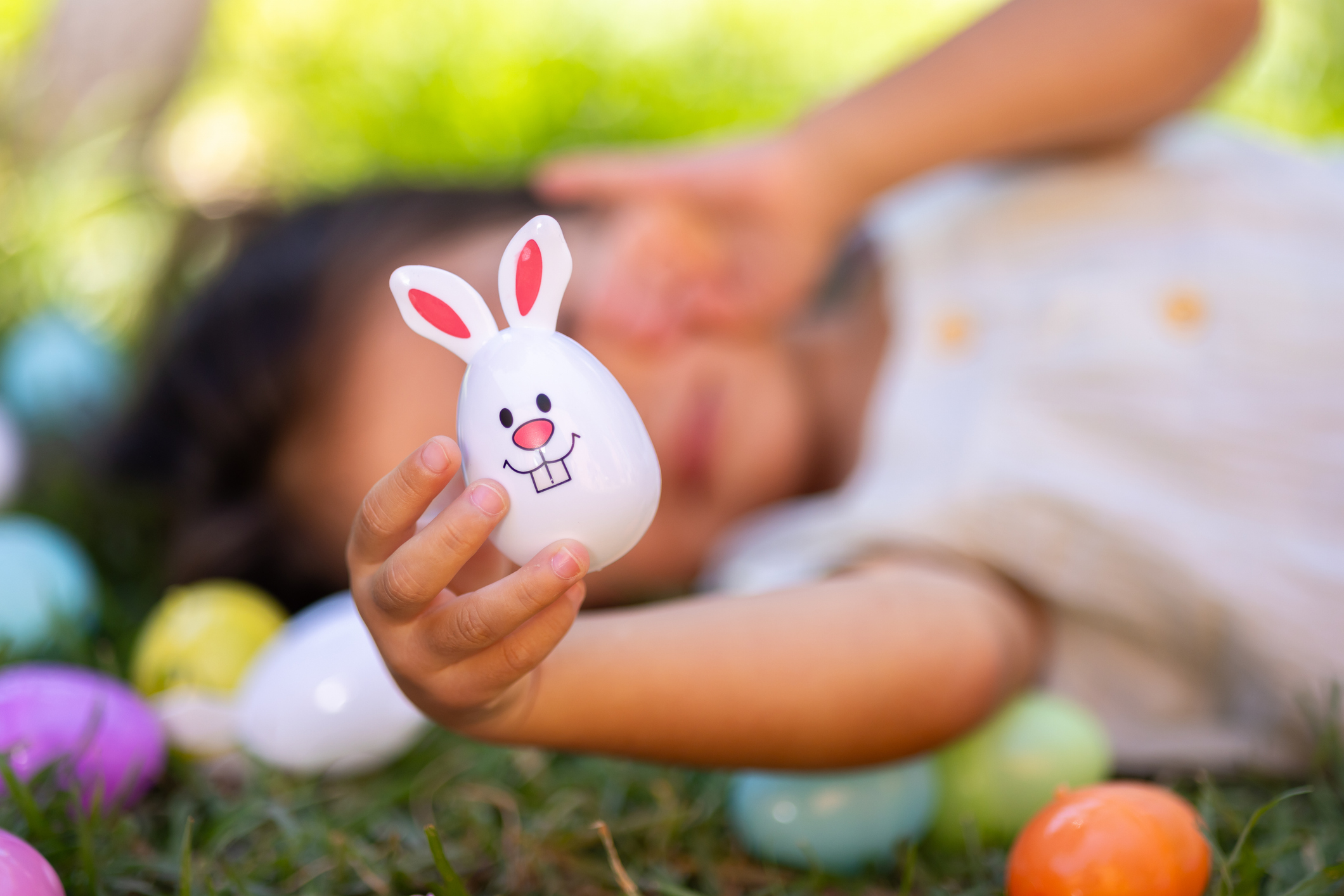 Little girl with her Easter eggs in her garden.