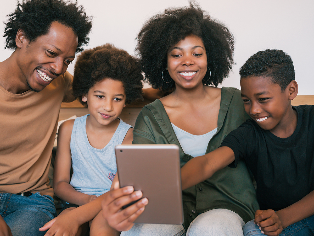 Portrait of african american family taking a selfie together with digital tablet at home. Family and lifestyle concept.