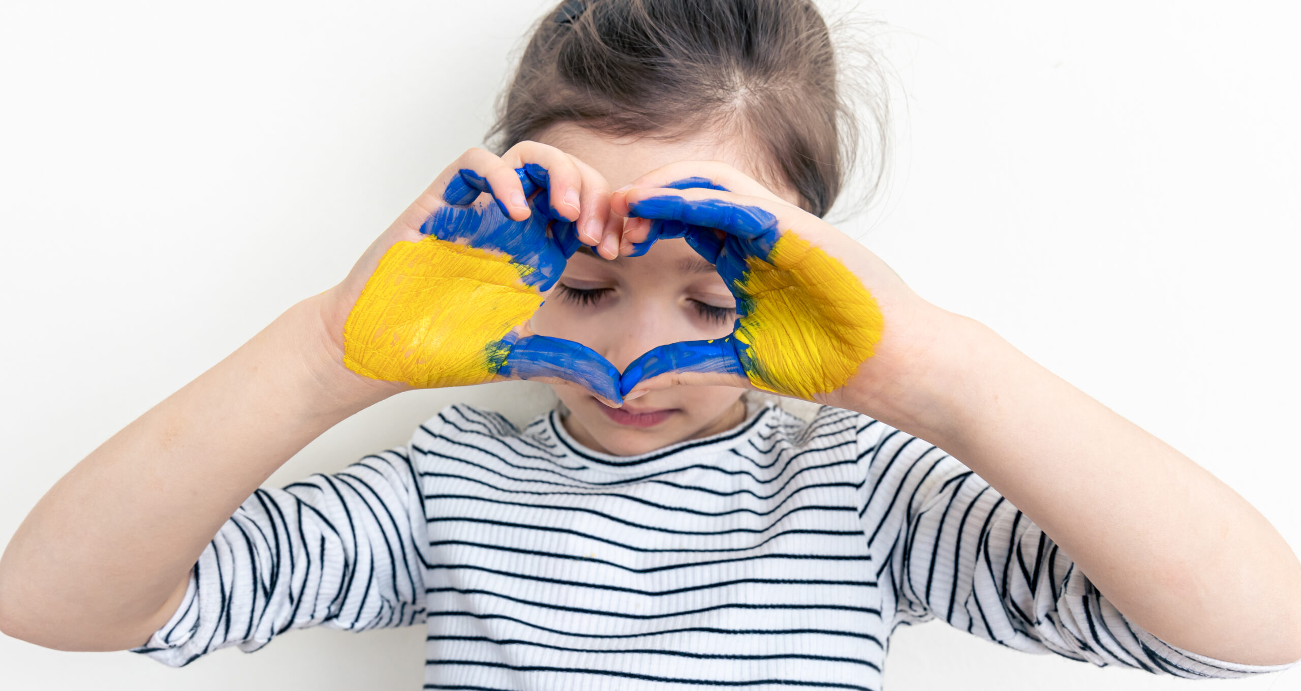 Children's hands are painted in the colors of the Ukrainian flag, request for help. Please stop the war. No war.
